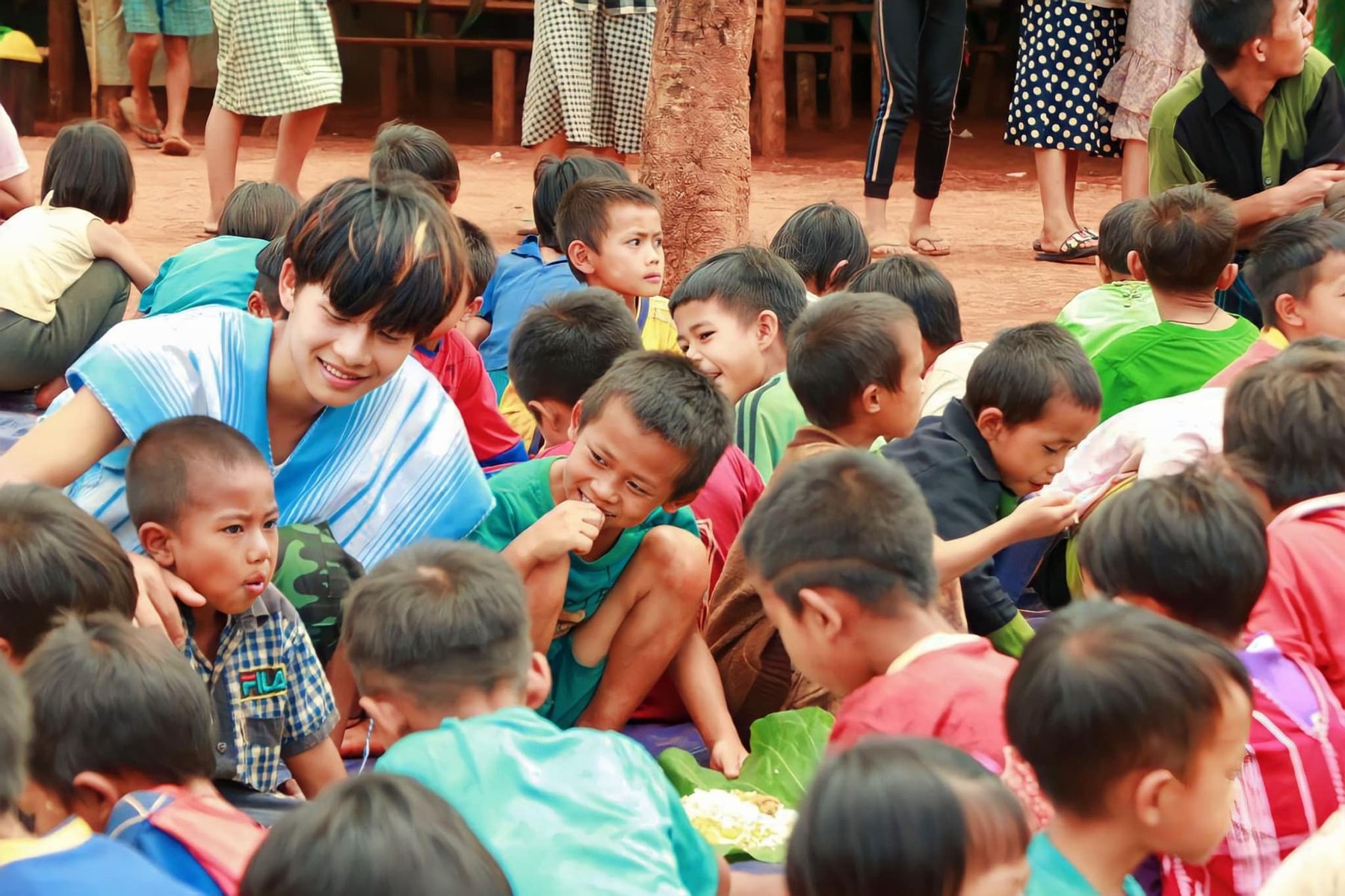A crowd of young children eat together, seen from close by.