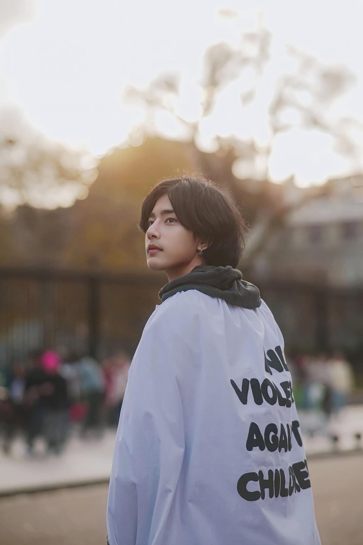 Wai Yan Aung, seen from behind in a white jacket with black lettering, looking back over his shoulder.