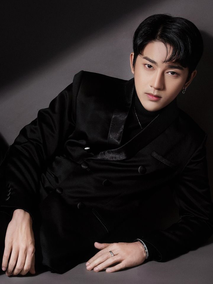 Wai Yan Aung dressed all in black, seated against a dark background.